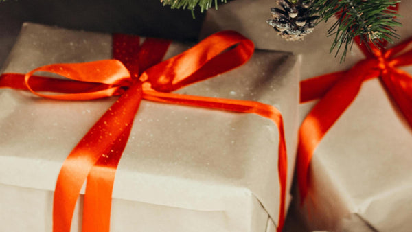 brown paper gift box with red ribbon tied around it